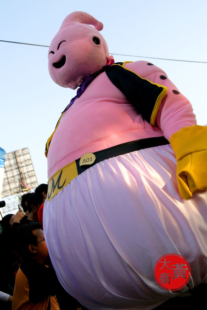 a large inflatable pig standing on top of a person's stomach at an event