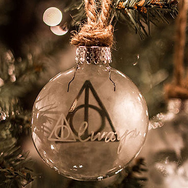 an ornament hanging from a christmas tree with the harry potter logo on it