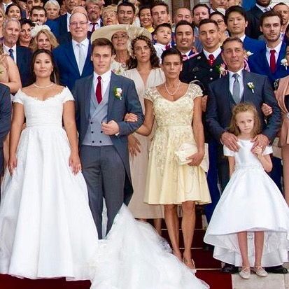 a large group of people posing for a wedding photo