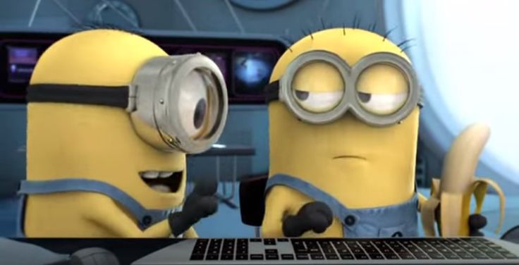 two minion characters sitting in front of a laptop computer with their eyes wide open