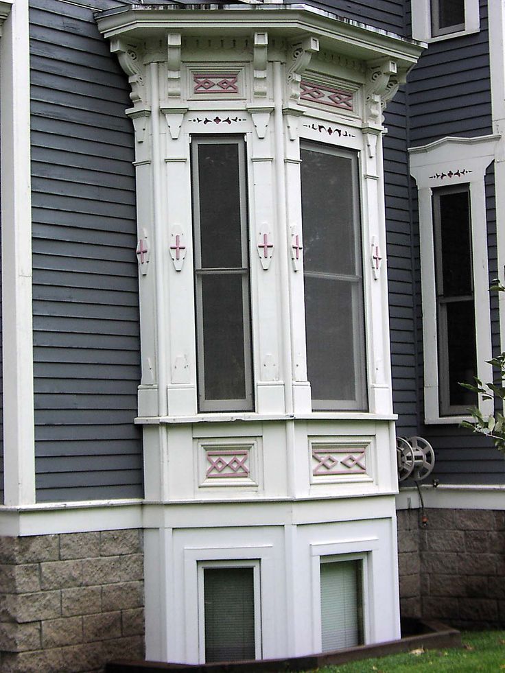 a tall white building sitting in front of a blue house