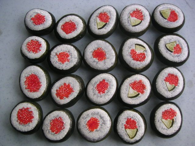 there are many sushi rolls on the table with red and white toppings in them