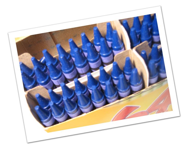 many blue crayons are lined up in a cardboard box with the top open