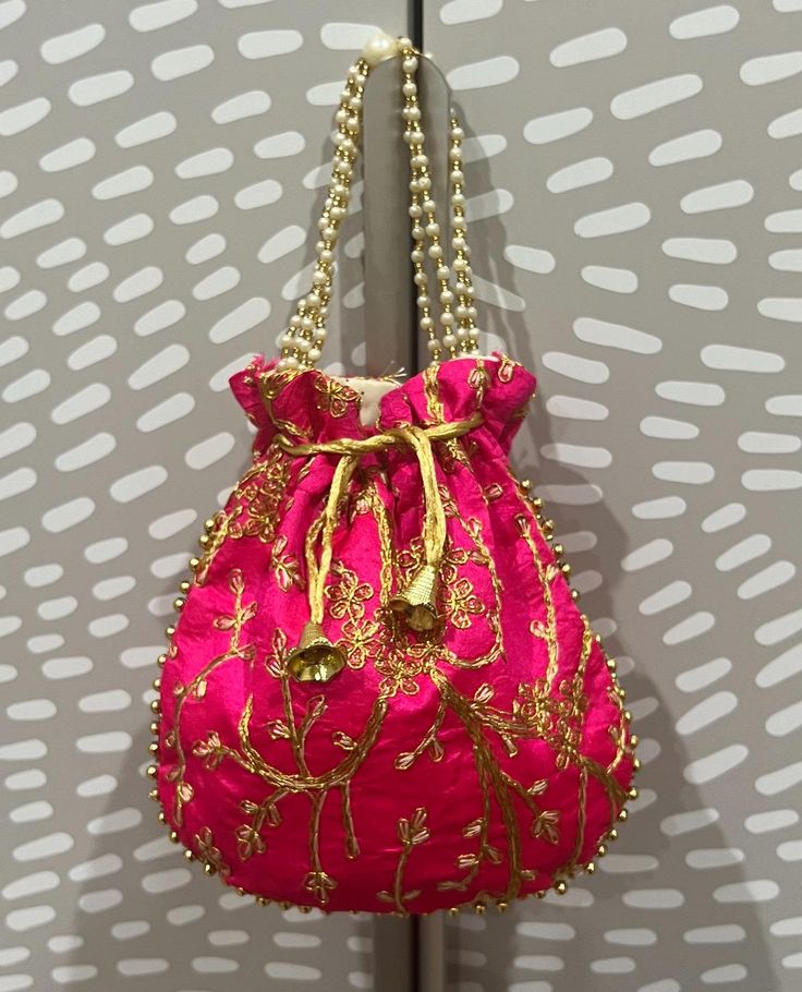 This is our beautiful Zardozi embroidered pouch. It comes with sequin threaded flowers.  This is perfect for storage at home or even for travel. This also makes for THE perfect gift!! DIMENSIONS:  8.5 inches length and 8 inches wide. Pink Bag With Zari Work For Gift, Pink Bags With Zari Work For Gift, Traditional Pink Shoulder Bag With Handwork, Festival Embroidered Evening Bag For Celebrations, Multicolor Embroidered Potli Bag With Handwork For Festivals, Gold Embroidered Pouch For Celebration, Pink Pouch Bag For Festive Occasions, Embroidered Pouch Potli Bag For Festive Occasions, Clutch Potli Bag With Dori Work For Gift