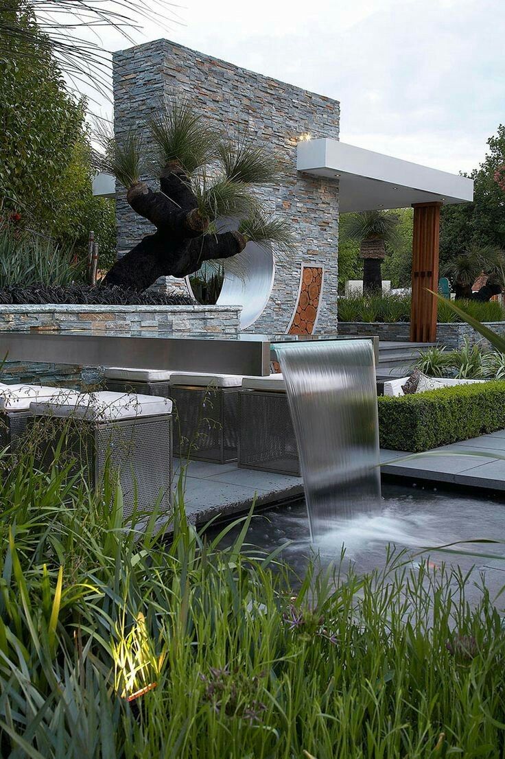 a water fountain in front of a modern house