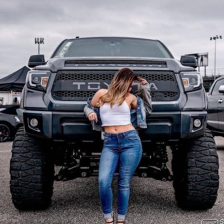 a woman standing in front of a large truck