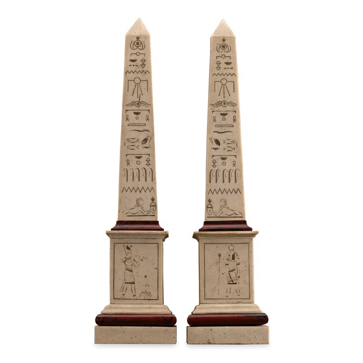 two egyptian obelis on pedestals, one in white and the other in red