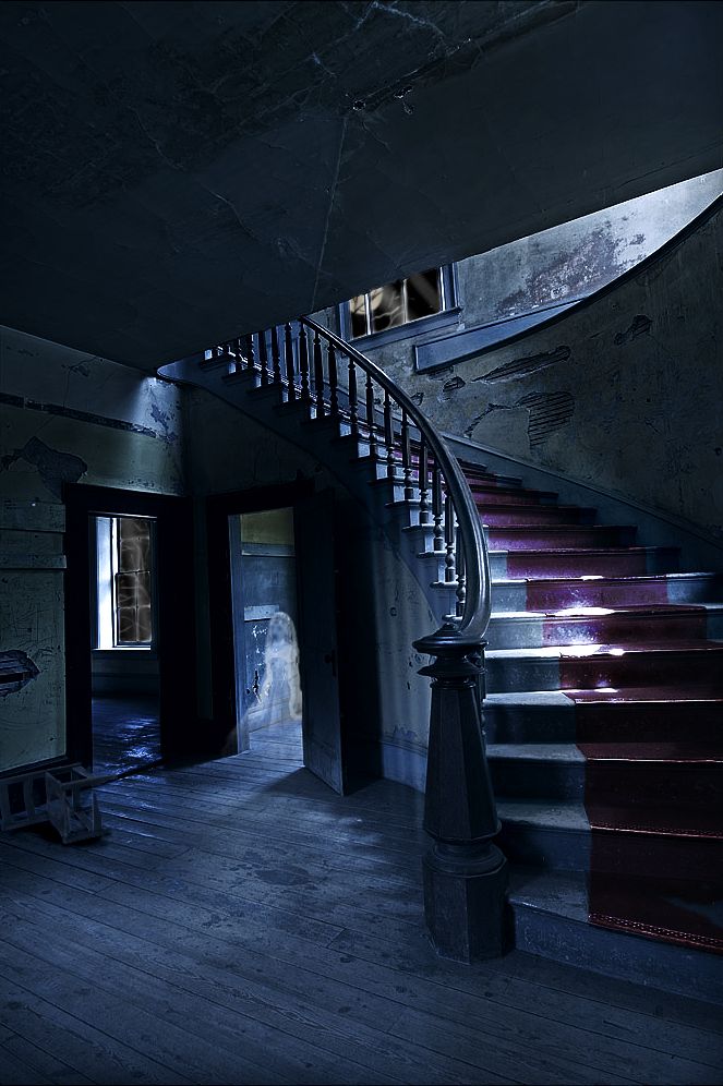 an empty staircase in the middle of a dark room with stairs leading up to it