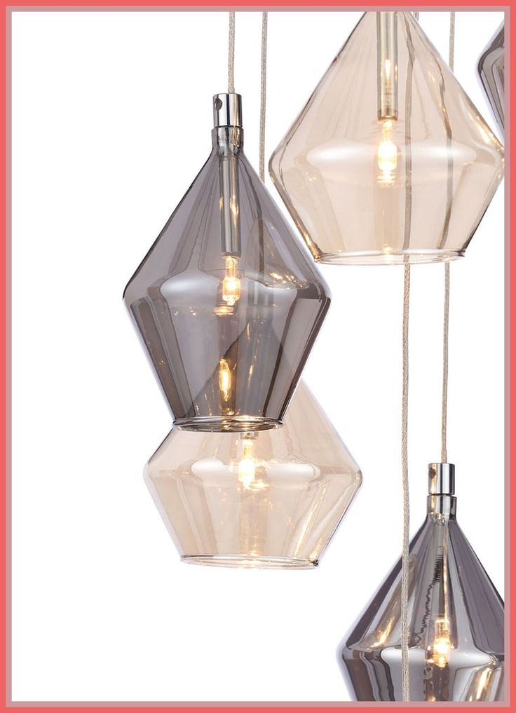 three clear glass pendant lights hanging from strings