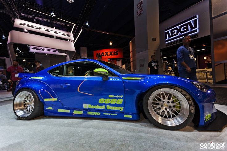 a blue sports car on display at an auto show