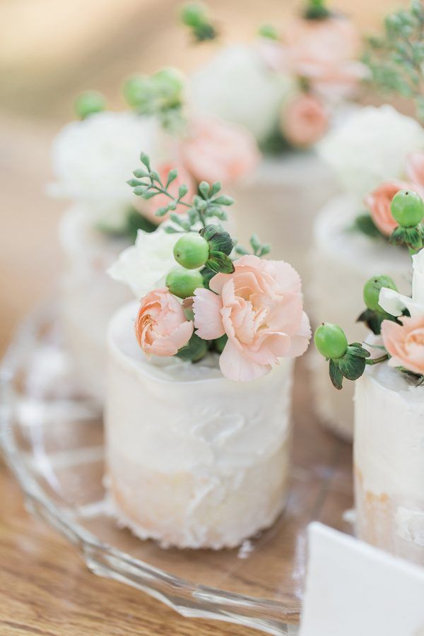 small wedding cakes with flowers on them are sitting on a glass platter, ready to be served