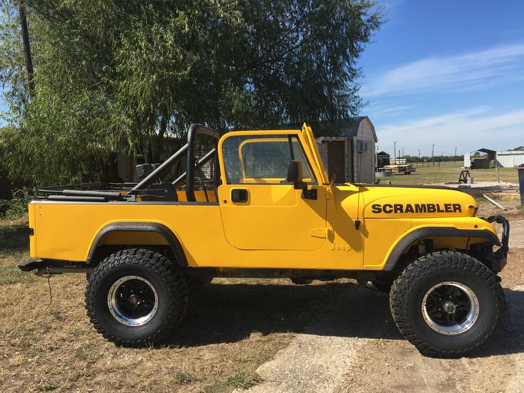 a yellow truck parked on top of a dirt field