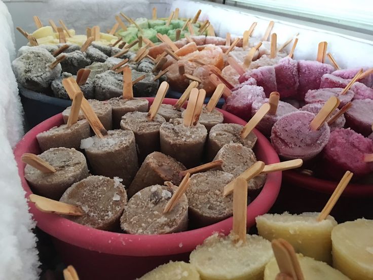 several bowls filled with different types of desserts and skewers on toothpicks