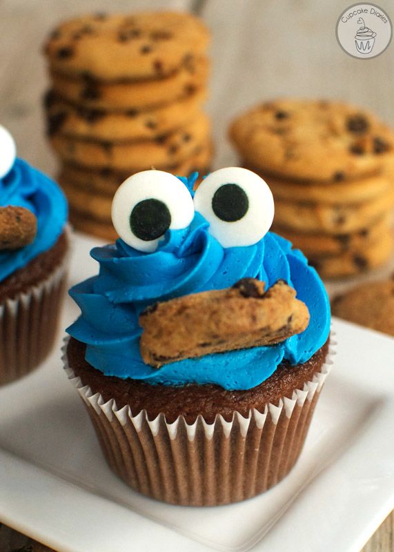 cookie monster cupcakes with blue frosting and googly eyes on white plate