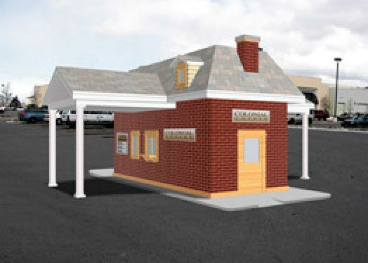 a small red brick building sitting in a parking lot