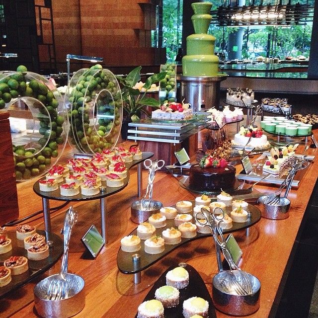 an assortment of cupcakes and pastries on a wooden table in a restaurant