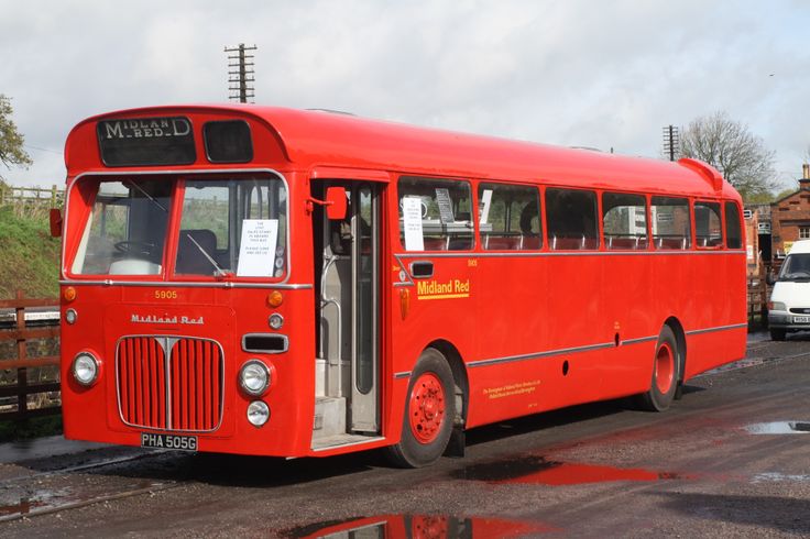 an old red bus is parked on the street