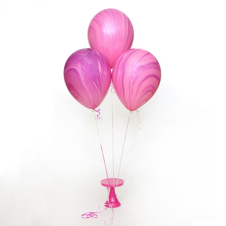 three pink balloons in a vase on a white background