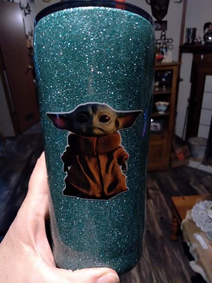 the child yoda star wars tumbler is being held by someone's hand