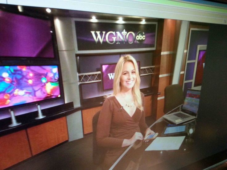 a woman is sitting in front of two televisions