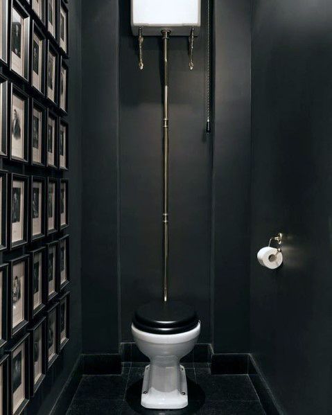 a bathroom with black walls and pictures on the wall