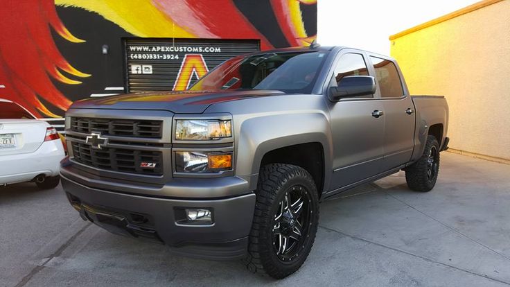 a silver truck parked in front of a building