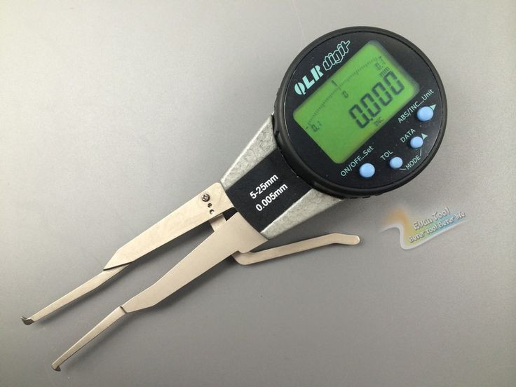 a digital caliper sitting on top of a table next to a pair of scissors