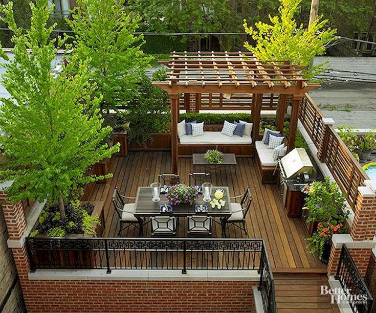 an outdoor deck with seating and tables surrounded by trees