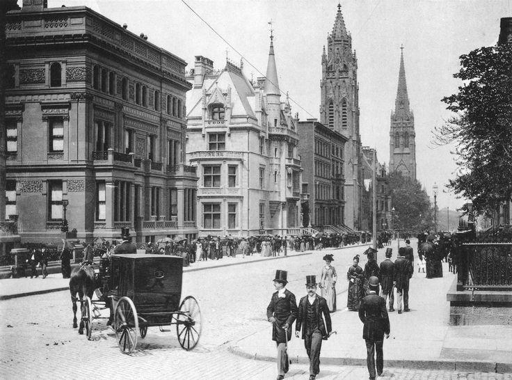 an old black and white photo shows people walking down the street in front of tall buildings