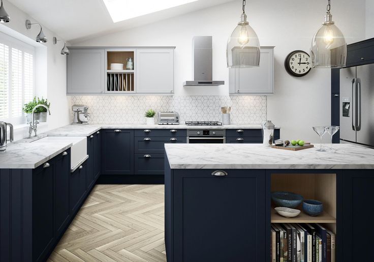 a kitchen with blue cabinets and an island in the middle is lit by two pendant lights