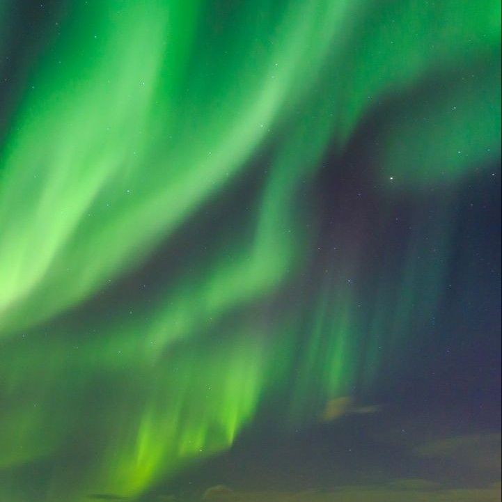 green and purple aurora lights in the night sky