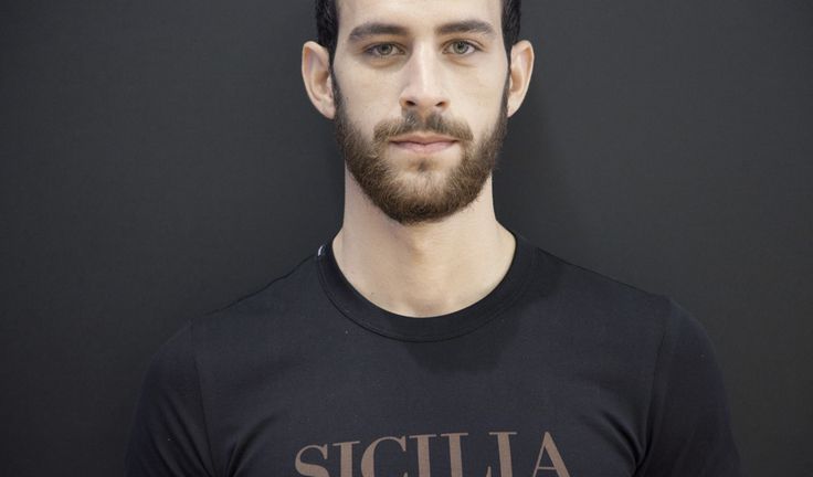 a man with a beard wearing a t - shirt that says sicula on it