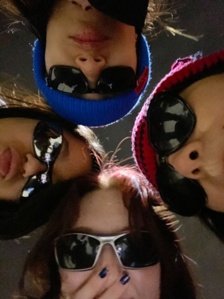 four people wearing sunglasses and hats with their faces together