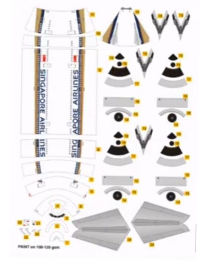 an airplane cut out from paper with the parts labeled in yellow and black on it