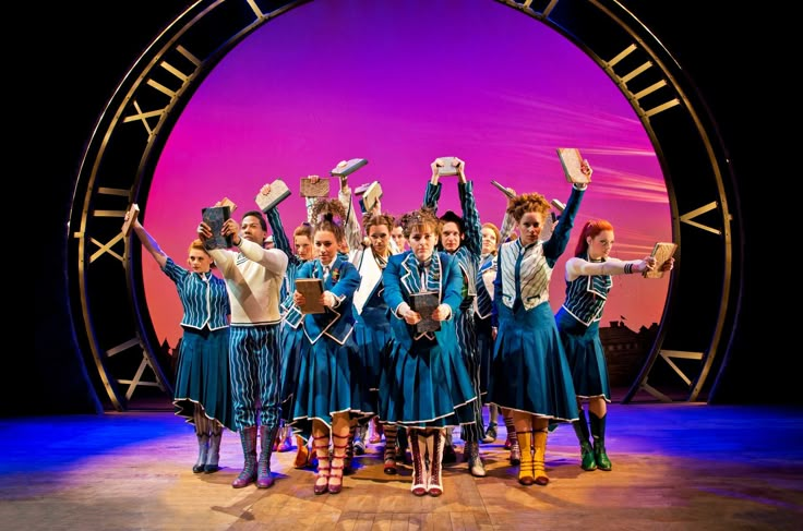 a group of people standing on top of a stage with their hands in the air