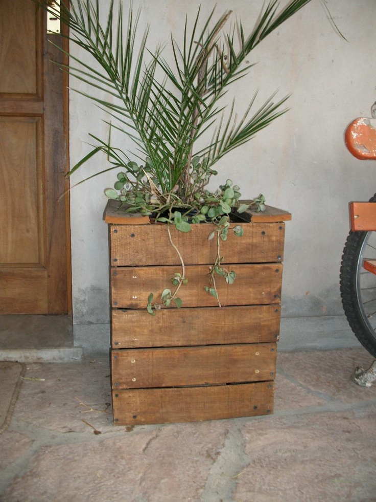 a wooden box with plants in it next to a bike