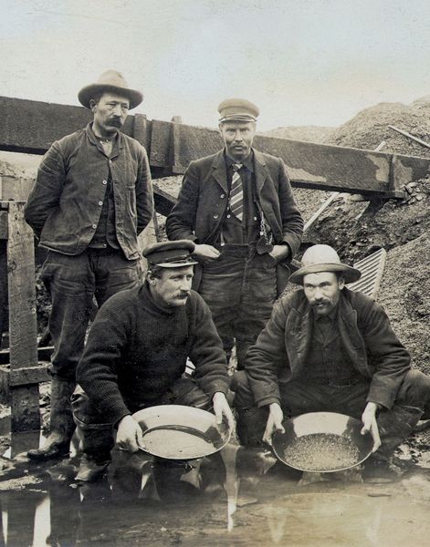 an old black and white photo of four men in uniforms standing next to each other