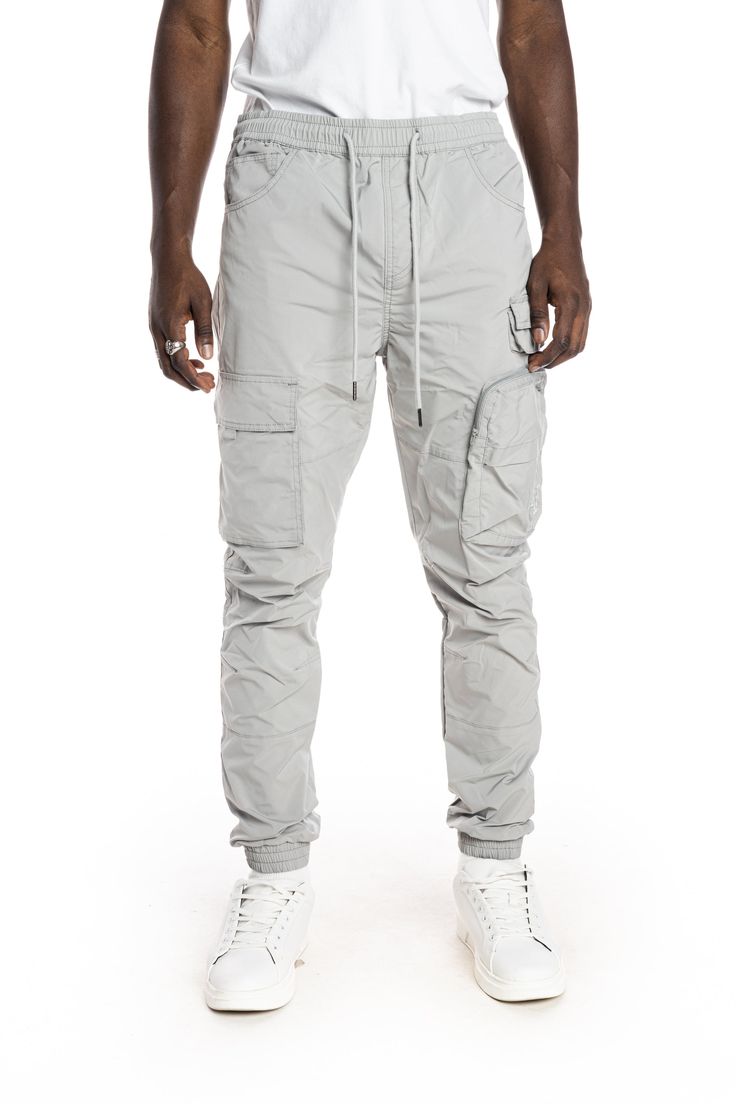 - Slim jogger fit- 100% Polyester- Light Grey- Non-stretchy woven fabric- Metal string tip- Cargo pockets with hidden snap- 3D zipper pocket- Waist size adjustable with elastic band and string Casual Gray Tapered Leg Cargo Pants, Athleisure Tapered Leg Pants With Cargo Pockets, Gray Athleisure Pants With Pockets, Casual Nylon Bottoms With Comfort Waistband, Nylon Cargo Pants With Tapered Leg And Pockets, Tapered Leg Nylon Cargo Pants With Pockets, Tapered Leg Nylon Cargo Pants, Nylon Tapered Leg Pants With Side Pockets, Functional Gray Cotton Bottoms