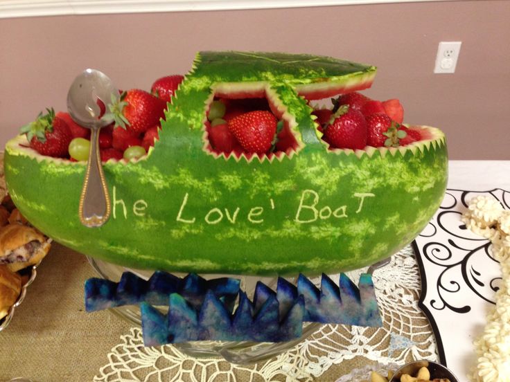 a watermelon boat shaped like a boat with strawberries in it