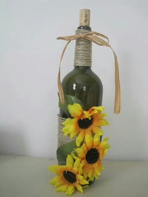 a bottle with sunflowers tied to it