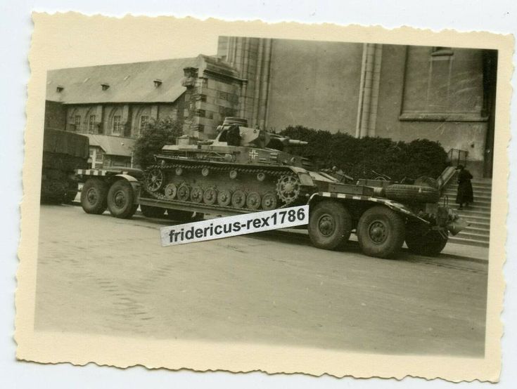 an old black and white photo of a tank on the back of a flatbed truck