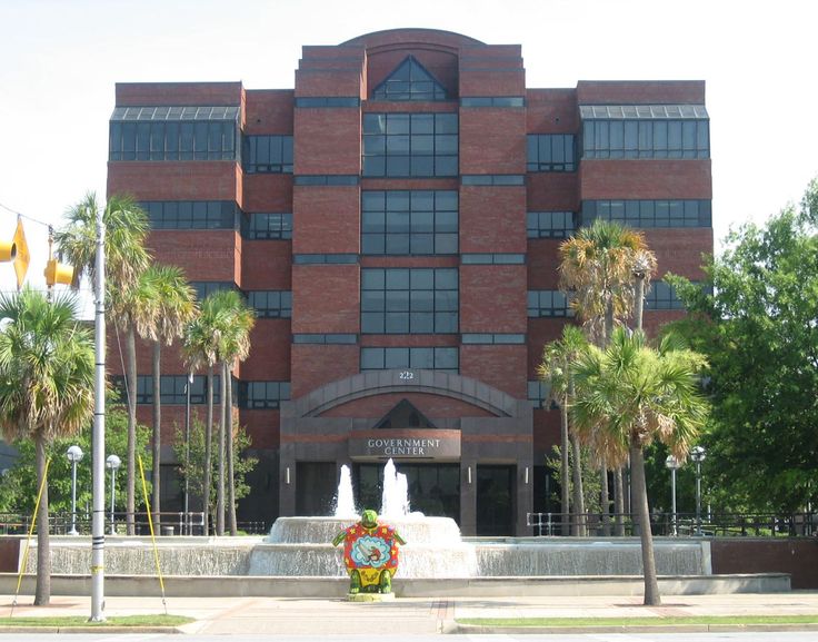 a large building with a fountain in front of it and palm trees around the corner