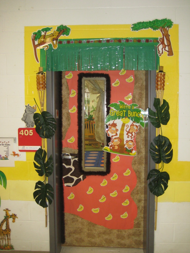 an animal themed door is decorated with fake leaves and plants, including a giraffe