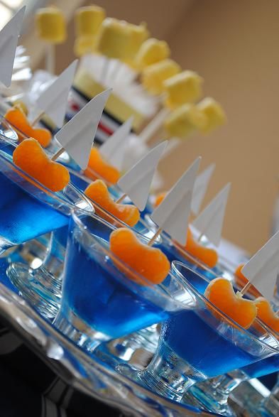 there are many small cups with oranges in them on the table and one is filled with blue liquid