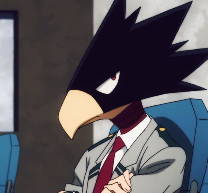 an angry bird wearing a suit and tie sitting in front of a computer monitor with his hands on his hips