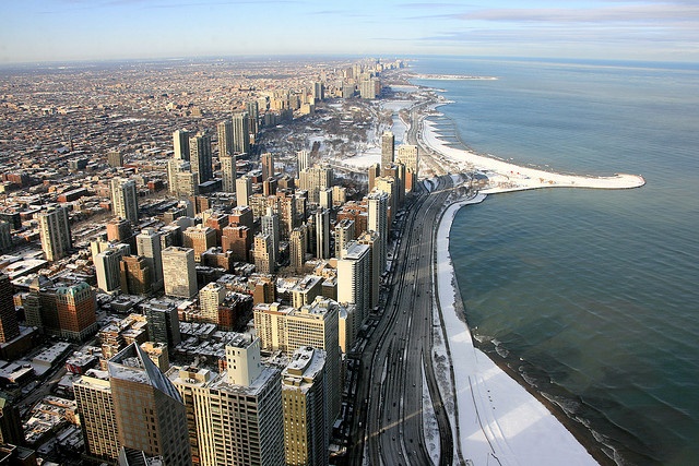 an aerial view of a city and the ocean in chicago, illinois on a sunny day