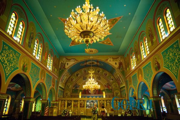 the inside of a church with chandelier and stained glass windows on both sides