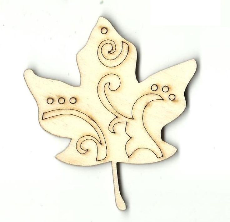 a wooden cutout of a leaf with swirls and leaves on the side,