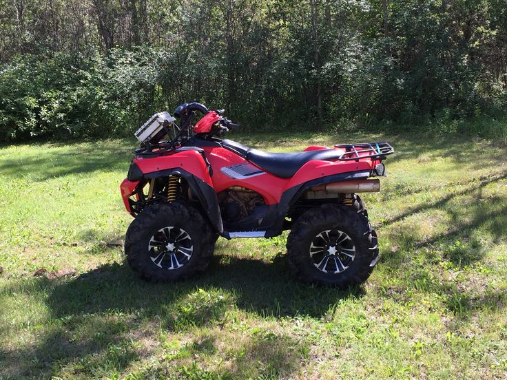 a red four wheeler parked in the grass