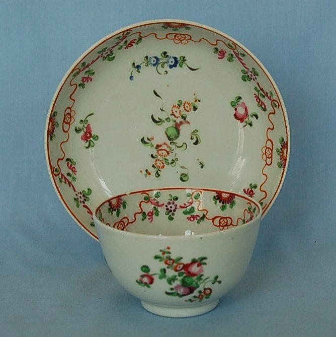 a white bowl with red and green flowers on the rim is sitting in front of a blue background